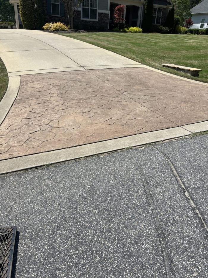 Stamped concrete driveway apron cleaned in front of a suburban home